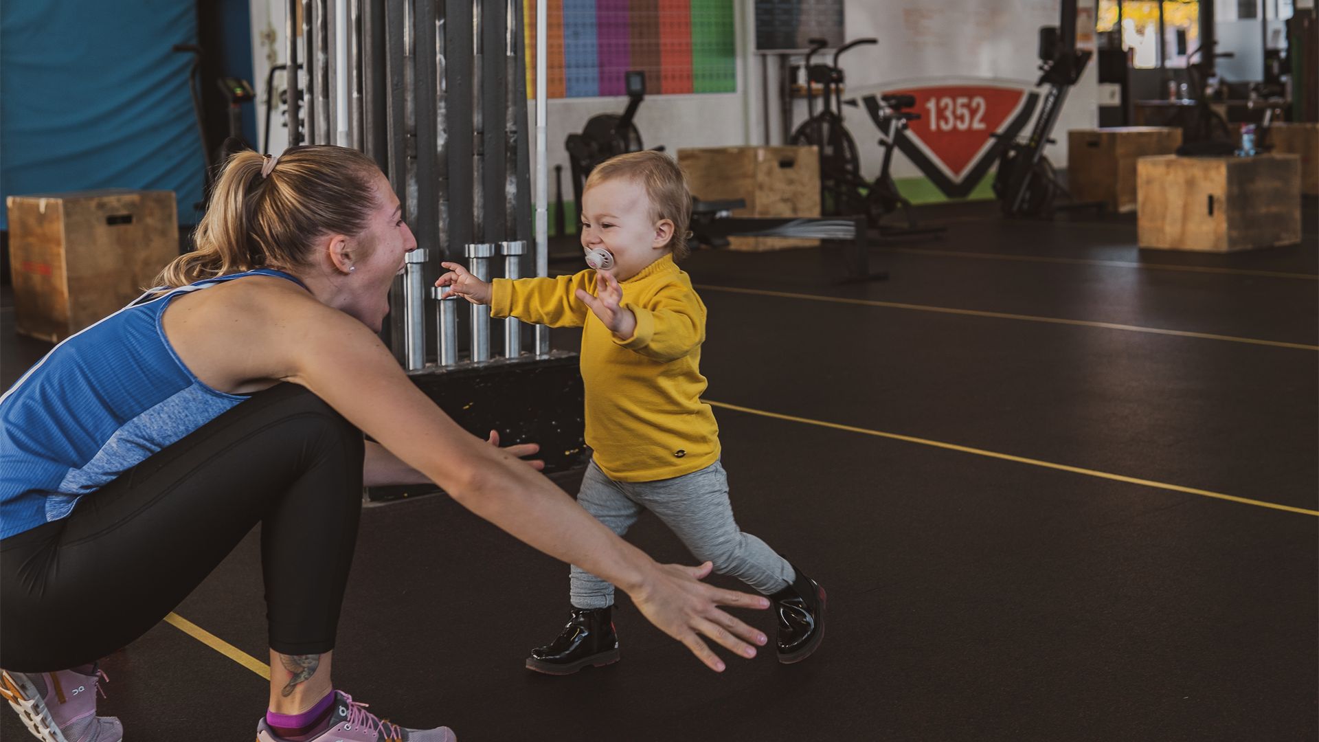 Mum playing ball with her toddler in the training hall