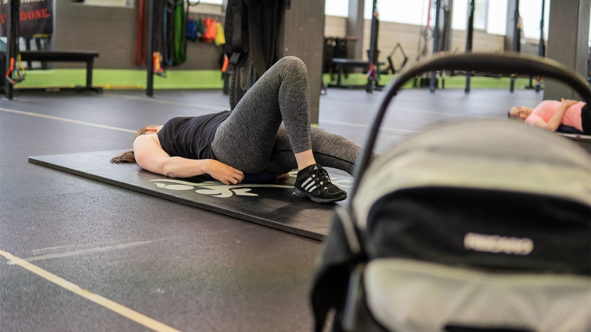 Mum training on the mat next to her stroller